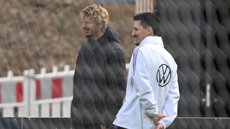 Nur Zuschauer beim Training: Nick Woltemade mit Co-Trainer Benjamin Hübner (r). - © Federico Gambarini/dpa