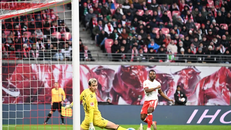 Bremens Torwart Mio Backhaus (l, Werder Bremen) und Ridle Baku (RB Leipzig) schauen dem Ball hinterher. Backhaus verhinderte mit seinen Paraden einen fr&uuml;hen R&uuml;ckstand der G&auml;ste in Leipzig. - &copy; Jennifer Br&uuml;ckner/dpa