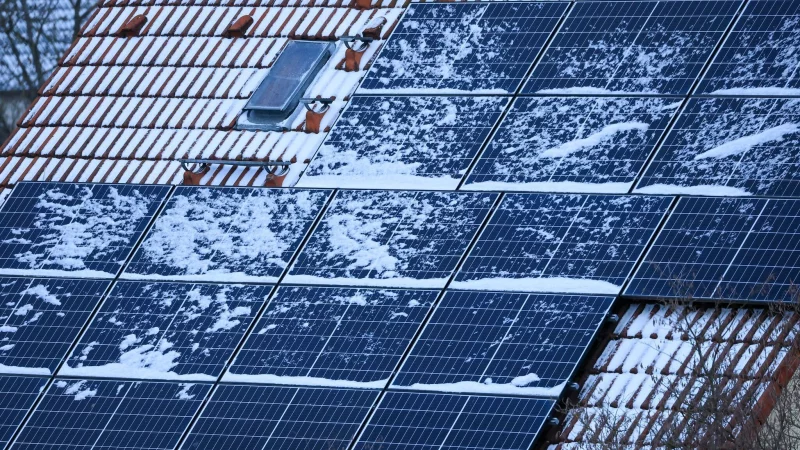 Schnee auf Solarmodulen kann im Winter den Stromertrag mindern: Doch das Abfegen von Schnee birgt Unfallgefahr und kann die empfindlichen Module besch&auml;digen. - &copy; Jan Woitas/dpa/dpa-tmn
