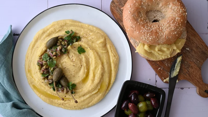 Der p&uuml;rierte Dip ist aus gelben Linsen zubereitet. Sie sind etwas weniger s&uuml;&szlig; und passen perfekt zu Kapern, Oliven und einem Sesambagel. - &copy; Julia Uehren/loeffelgenuss.de/dpa-tmn