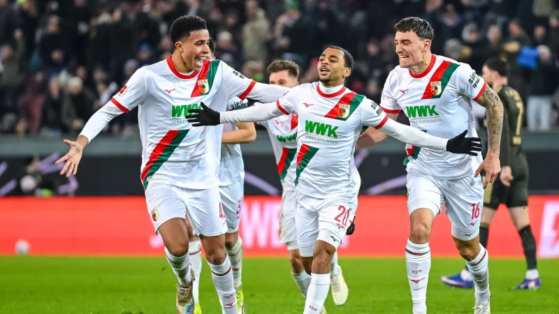 Alexis Claude-Maurice (M) jubelt nach seinem Traumtor mit seinen FCA-Kollegen. - &copy; Harry Langer/dpa