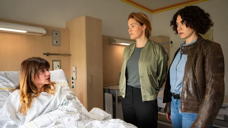 Eva Lackner (l, Julia Rosa Peer) wird im Krankenhaus von Lu Frey (2.v.l, Patricia Aulitzky) und Irene Russmeyer (Fanny Krausz) verh&ouml;rt (undatierte Filmszene). Der Krimi &laquo;Die Toten von Salzburg - Die letzte Reise&raquo; l&auml;uft am 28.01.2026 im ZDF. - &copy; Lisa Kutzelnig/ZDF/dpa