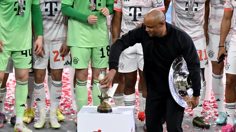 Bayern-Trainer Vincent Kompany stellt bei der Meisterparty eine Kakadu-Figur auf den Sockel. - © Sven Hoppe/dpa