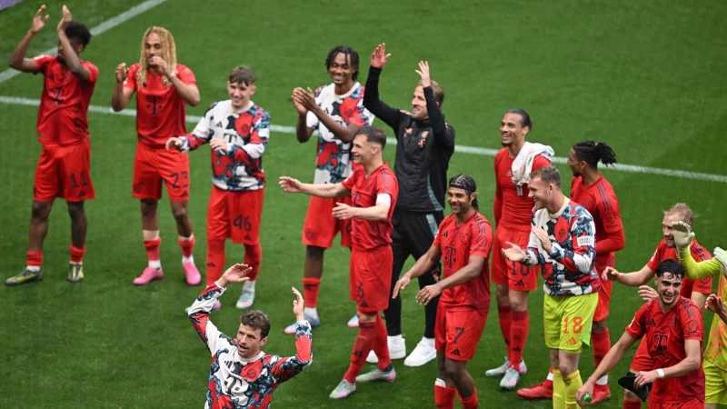 Thomas M&uuml;ller (vorne) stimmte nach dem 3:3 in Leipzig die Welle mit den Fans an. - &copy; Hendrik Schmidt/dpa