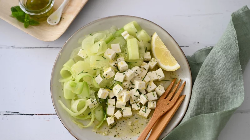 Mit dem Sparschäler gelingen hauchdünne Scheiben von der Honigmelone und Gurke. Sie geben dem Salat eine spezielle Textur. - © Julia Uehren/loeffelgenuss.de/dpa-tmn