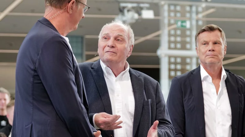 Uli Hoene&szlig; (m) bezieht im Doppelpass Stellung. - &copy; Uwe Lein/dpa