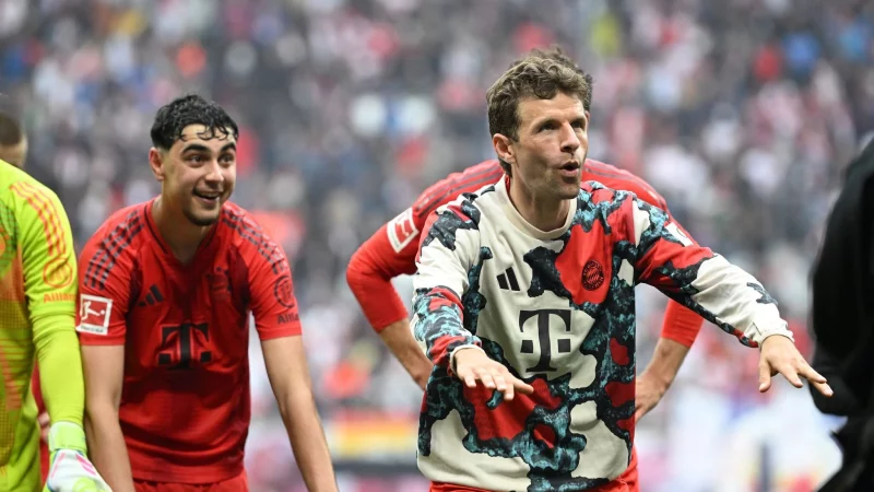 Thomas Müller (r) feiert vor der Bayern-Kurve in Leipzig. - © Elisa Schu/dpa