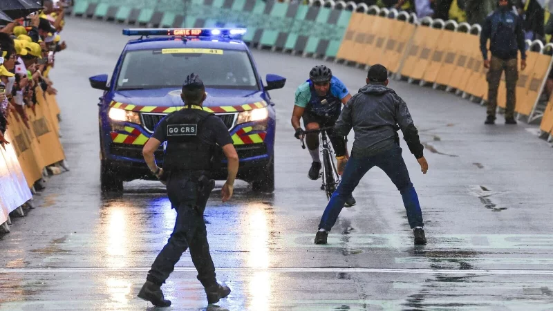 Ein Mann fuhr bei der 17. Tour-Etappe mit seinem Rad unmittelbar vor der Ankunft der Profis in den Zielbereich. - © Stefano Cavasino/LiveMedia-IPA/ZUMA Press Wire/dpa