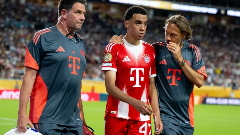 Jamal Musiala musste nur 25 Minuten nach seiner Einwechselung angeschlagen vom Platz, begleitet von Teamarzt (r) und Physiotherapeut. - © Sven Hoppe/dpa