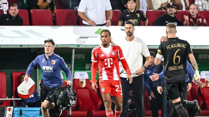 Bayern-Profi Sacha Boey (M.) sah für sein Foul an Augsburgs Robin Fellhauer Gelb. - © Harry Langer/dpa