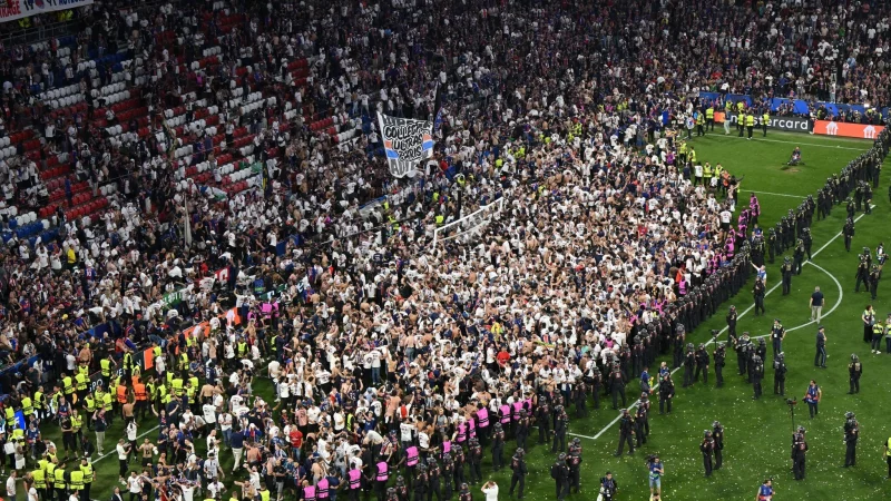 Party auf dem Rasen: Pariser Fans stürmen aus ihrem Block. - © Peter Kneffel/dpa