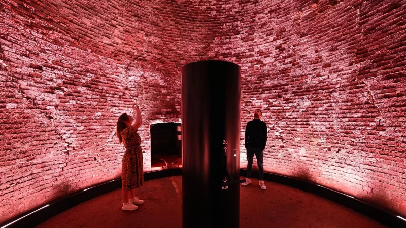 Höllenmaschine mit Lichtkunst: Der 98 Meter hohe Schornstein der Kokerei Zollverein leuchtet rot als Teil des erweiterten Denkmalpfads. - © Federico Gambarini/dpa/dpa-tmn
