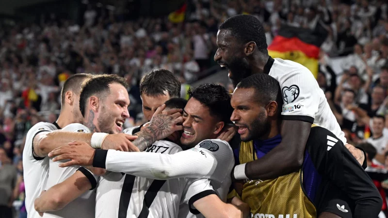 Florian Wirtz wird f&uuml;r sein Freisto&szlig;tor von den Teamkollegen bejubelt. - &copy; Federico Gambarini/dpa