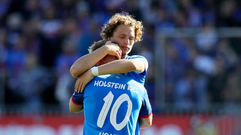 Kiels Lewis Holtby (vorne) wird nach dem Abstieg von Teamkollege Fiete Arp getröstet. - © Claus Bergmann/dpa