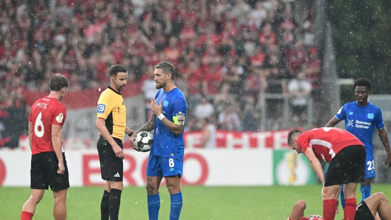 Schiedsrichter Michael Bacher (2.v.l.) muss das Spiel in Gro&szlig;aspach unterbrechen - &copy; Bernd Wei&szlig;brod/dpa
