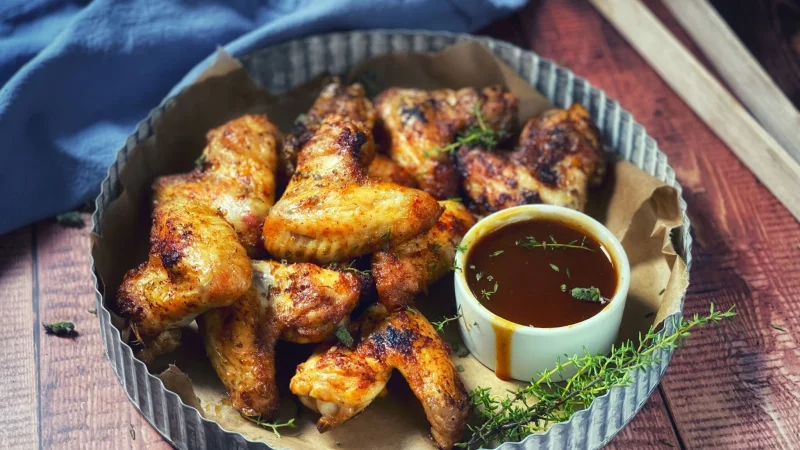 Damit nichts in die Glut tropft, empfiehlt sich für die Chicken Wings eine sämige Marinade aus Trockengewürzen. - © Anja Würfl/die-frau-am-grill.de/dpa-tmn