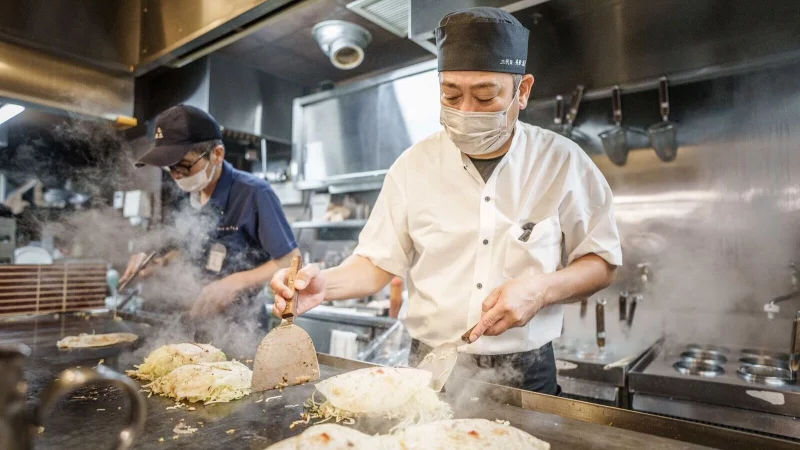 Okonomiyaki ist ein japanisches Gericht. Okonomi bedeutet «was du magst», yaki bedeutet «gebraten» oder «gegrillt». Traditionell wird Okonomiyaki am Tisch auf einer heißen Eisenplatte mit einem Spatel gebraten. - © Michael Kappeler/dpa/dpa-tmn