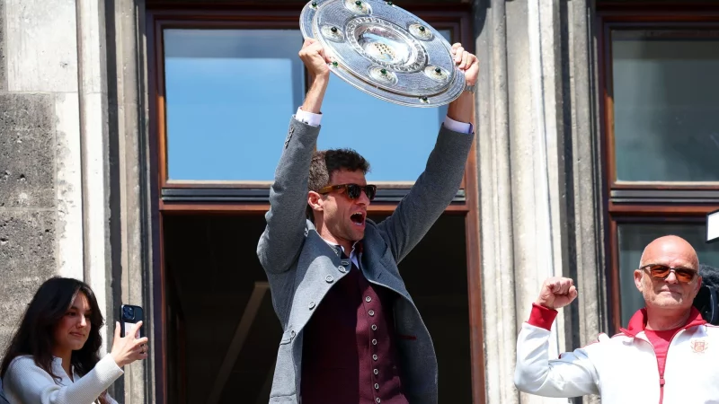 Thomas Müller jubelt mit der Meisterschale auf dem Rathausbalkon. - © Karl-Josef Hildenbrand/dpa