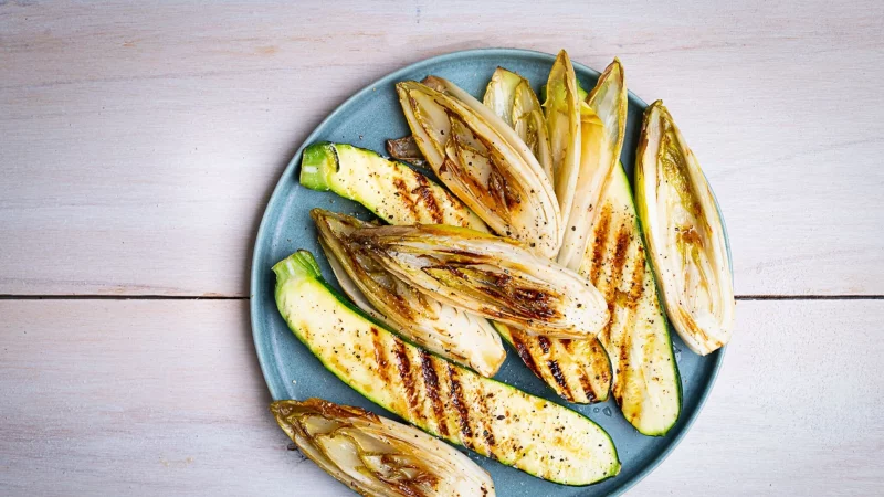 Die länglich geschnittenen Zucchini- und Chicorée-Streifen werden mit einer Marinade aus Olivenöl, Limettensaft, Salz und Pfeffer eingepinselt, dann auf jeder Seite 2–3 Minuten gegrillt. - © Ariane Bille/BVEO/dpa-tmn