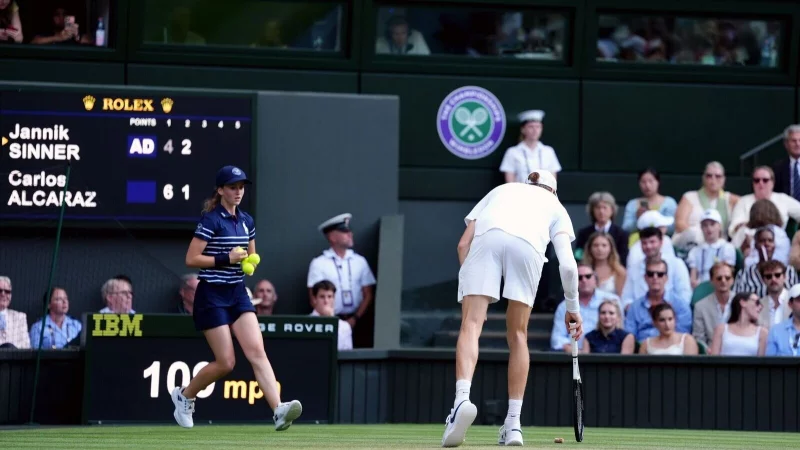 Was liegt denn da? Jannik Sinner hebt einen Champagnerkorken auf. - &copy; Adam Davy/PA Wire/dpa