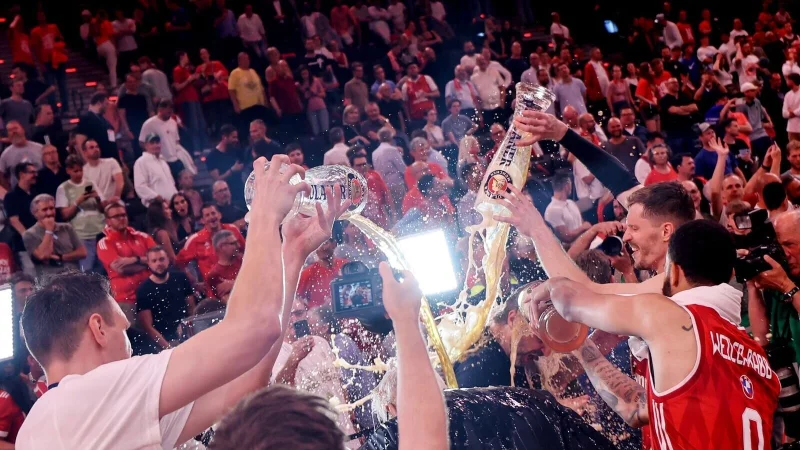 Die Bayern-Basketballer überschütten Coach Herbert mit Bier. - © Matthias Stickel/dpa