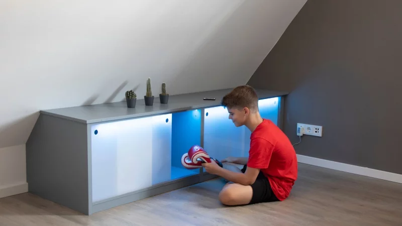 Stauraum unter der Dachschräge: Die Schiebetüren aus Acrylglas werden mit Hilfe eines LED-Bandes von innen indirekt beleuchtet. - © Michael Müller-Münker/Selbst ist der Mann/dpa-tmn