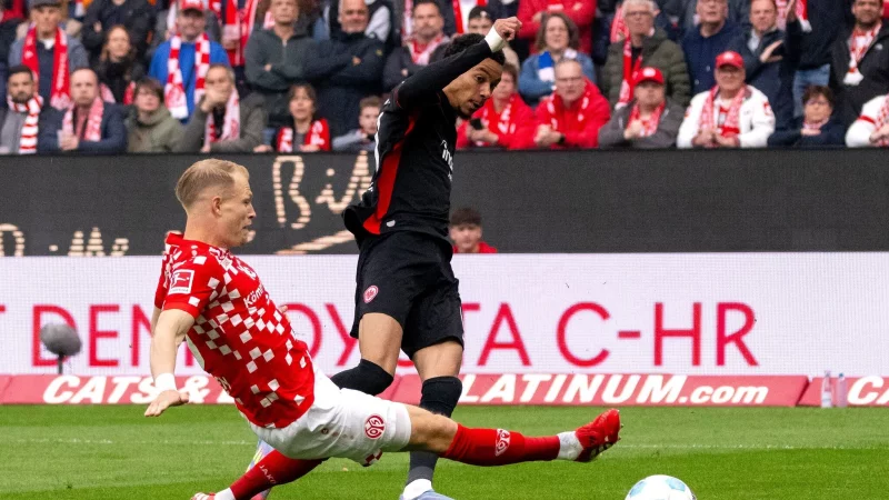 Der FSV Mainz 05 um Andreas Hanche-Olsen (l) und Eintracht Frankfurt um Hugo Ekitiké (r) lieferten sich ein hitziges Derby - © Torsten Silz/dpa