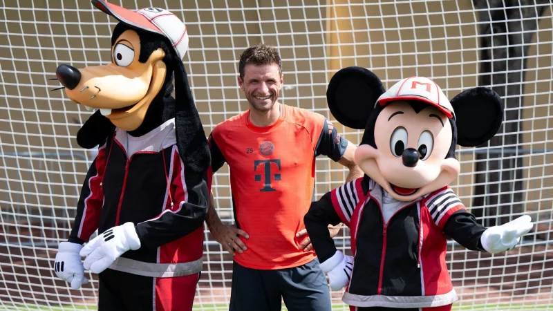 Thomas Müller mit Goofy und Micky Maus. - © Sven Hoppe/dpa