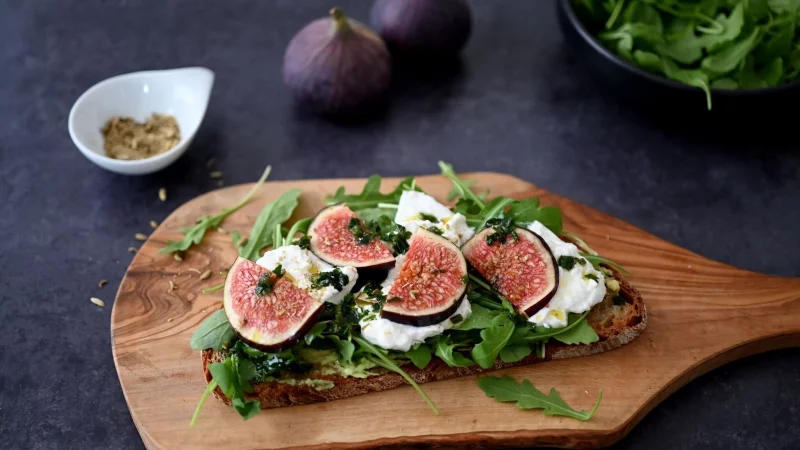 Das Butterbrot wird zunächst in der Pfanne knusprig angebraten. Belegt mit Rucola, Burrata und Feigen wird es zum Bauernbrot. - © Julia Uehren/loeffelgenuss.de/dpa-tmn
