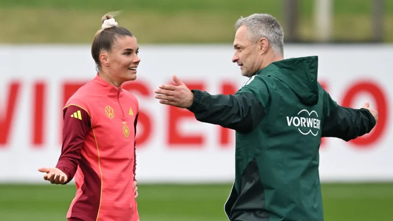 Vorfreude auf die EM: Christian Wück (mit Stürmerin Selina Cerci) - © Arne Dedert/dpa