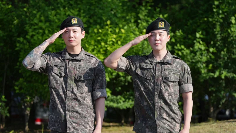 Die Mitglieder der K-Pop-Band BTS, Jimin (r) und Jung Kook, salutieren nach ihrer Entlassung aus dem Milit&auml;rdienst. - &copy; Lee Jin-man/AP/dpa