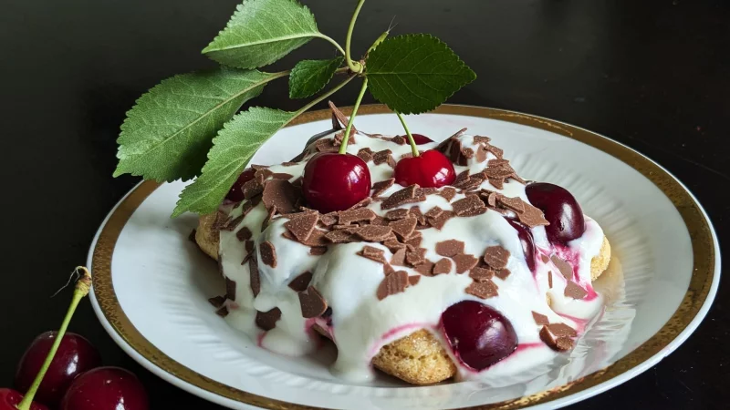 Auf die mit Espresso getr&auml;nkten L&ouml;ffelbiskuits kommen eine Quark-Sahne-Masse und reichlich Kirschen. Das Tiramisu wird mit Schokoraspeln getoppt. - &copy; Doreen Hassek/hauptstadtkueche.blogspot.com/dpa-tmn