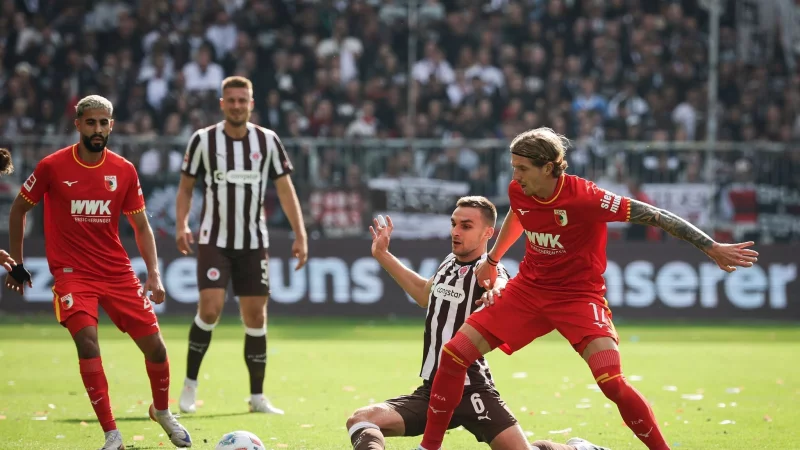 Im Zweikampf: Kristijan Jaki? vom FC Augsburg (r) und St. Paulis James Sands. - &copy; Christian Charisius/dpa