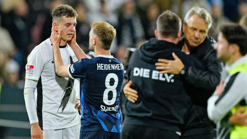 Erst Siegtorschütze, dann Tröster: Scienza muntert Asllani auf. - © Uwe Anspach/dpa