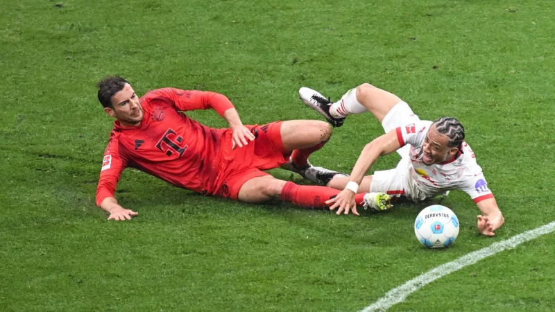 Leon Goretzka (l) und Leipzigs Xavi Simons kämpfen um den Ball. - © Hendrik Schmidt/dpa