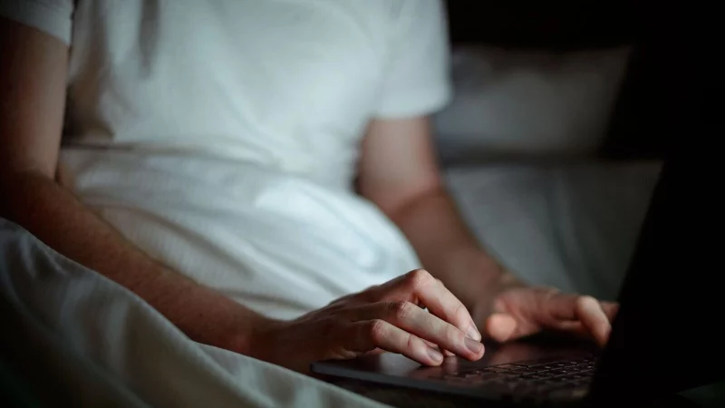 Gem&uuml;tlich im Bett zu arbeiten ist verlockend, doch Notebooks sollten auf festen und ebenen Unterlagen stehen, damit die Luftzirkulation nicht behindert wird. - &copy; Sina Schuldt/dpa/dpa-tmn