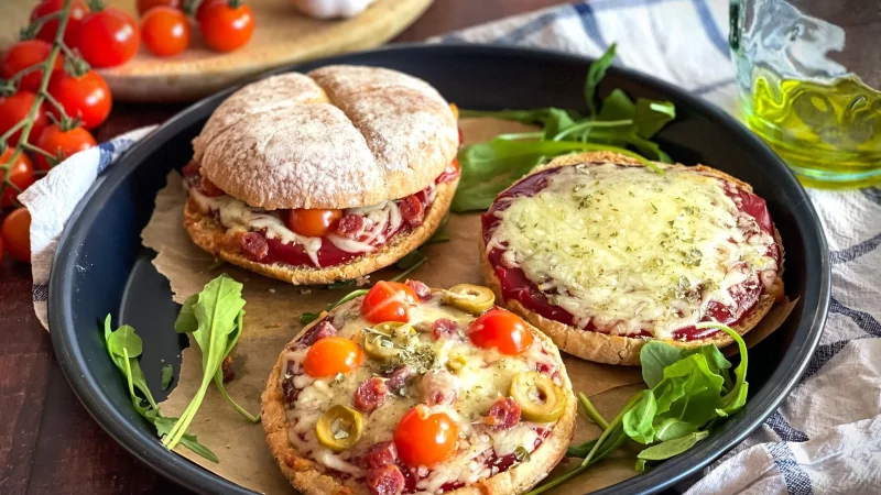 Ein rustikales Hamburgerbr&ouml;tchen wird zur Pizzabasis, belegt mit Tomatenketchup, geschmolzenem Mozzarella und mediterranen Zutaten. - &copy; Anja W&uuml;rfl/die-frau-am-grill.de/dpa-tmn