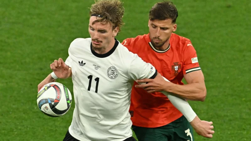 Nick Woltemade (l) hatte bei seinem Länderspiel-Debüt gegen Portugals Abwehrrecken einen schweren Stand. - © Peter Kneffel/dpa