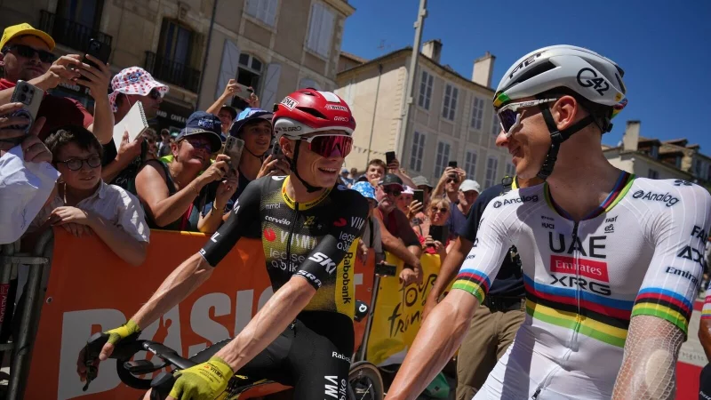Der Däne Jonas Vingegaard (l) und der Slowene Tadej Pogacar (r) unterhalten sich vor dem Start. - © Thibault Camus/AP/dpa
