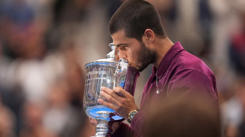 Ein Küsschen für den Pokal: Alcaraz ist neuer US-Open-Champion. - © Seth Wenig/AP/dpa