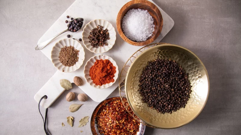 Zur Grundausstattung in der Küche gehören Salz, schwarzer Pfeffer, Chili-Flocken, Paprika edelsüß oder geräuchert, Kümmel, Nelken, Wachholderbeeren, Lorbeer und Muskatnuss. - © Christin Klose/dpa-tmn