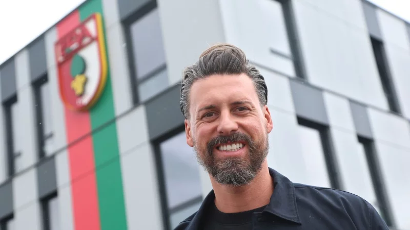 Der neue Trainer Sandro Wagner posiert vor der Geschäftsstelle des FC Augsburg. - © Karl-Josef Hildenbrand/dpa
