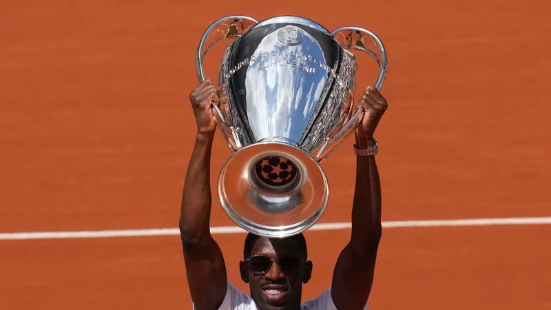 PSG-Star Ousmane Demb&eacute;l&eacute; pr&auml;sentiert bei den French Open den Champions-League-Pokal. - &copy; Christophe Ena/AP/dpa