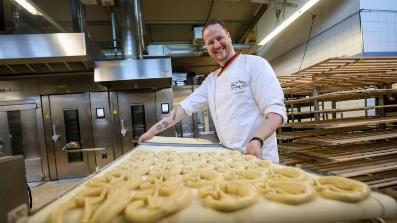 Backen ist Kunst: Brot-Sommelier Florian Lutz steht in seiner Backstube und schiebt ein Blech Brezeln in den Ofen. - &copy; Christoph Schmidt/dpa-tmn