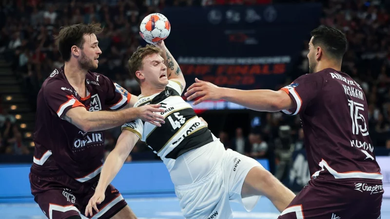 Kiels Emil Madsen (M) wird von Montpeliers Veron Nacinovic am Wurf gehindert. - © Christian Charisius/dpa