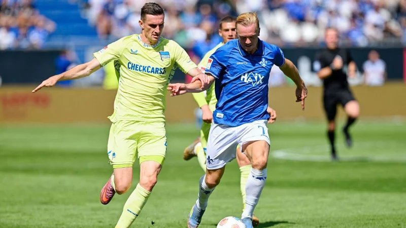 Herthas Niklas Kolbe (l) und Darmstadts Isac Lidberg kämpfen um den Ball. - © Uwe Anspach/dpa