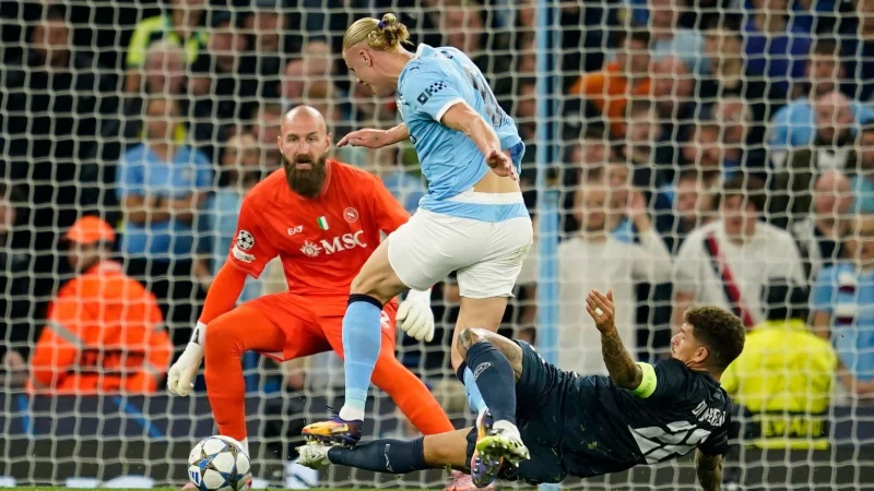 F&uuml;r dieses Foul sah Di Lorenzo (rechts) Rot, Haaland traf gegen Neapel dennoch - und hat nun 50 Champions-League-Tore erzielt. - &copy; Dave Thompson/AP/dpa