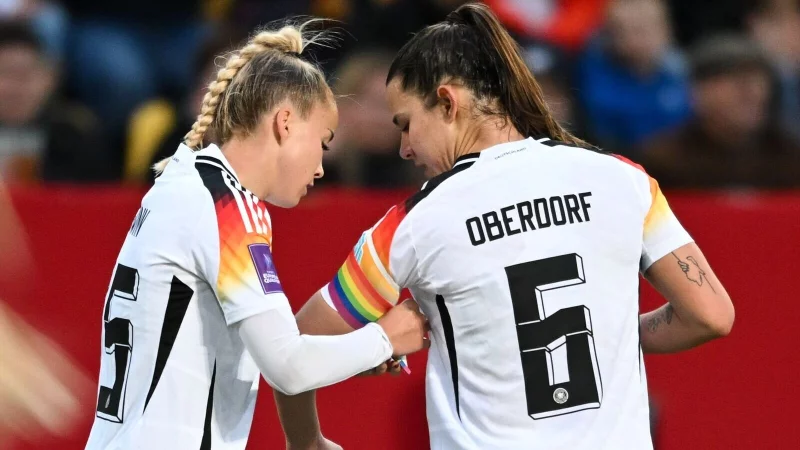 Giulia Gwinn (l.) trägt die Regenbogenbinde bei der EM - © Sebastian Christoph Gollnow/dpa