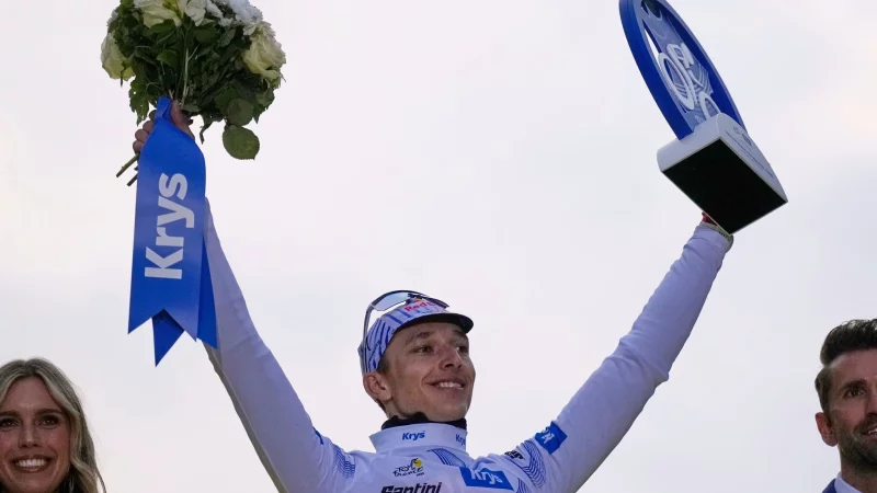 Florian Lipowitz jubelt auf dem Podium in Paris über seinen dritten Platz bei der Tour de France. - © Mosa\\\'ab Elshamy/AP/dpa