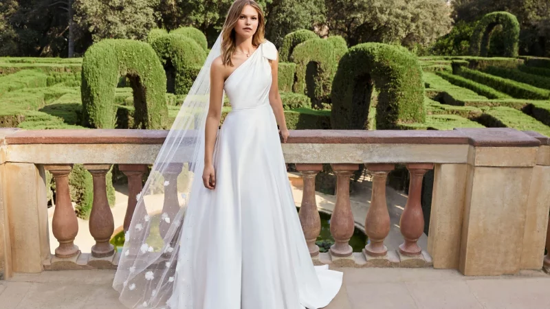 3D-Blüten sind 2025 in der Brautmode besonders beliebt, ob als Anstecker oder auf der Schleppe wie von Lilly. - © Lilly/dpa-tmn